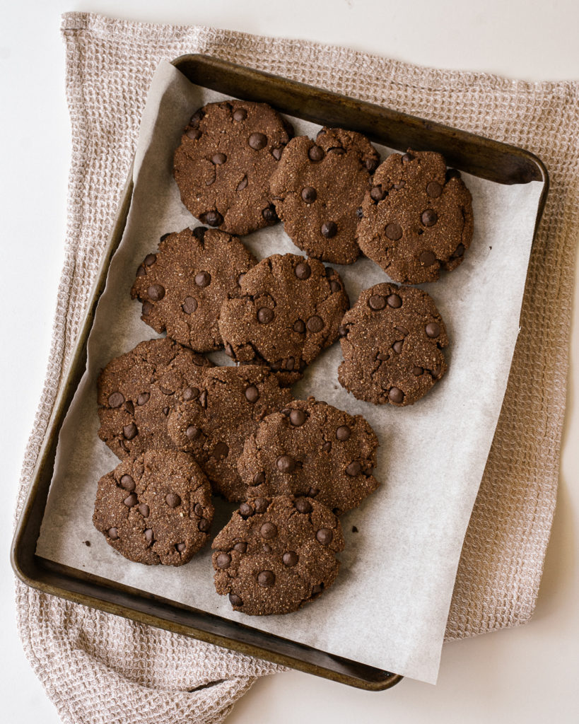 11 baked gluten free dark chocolate almond flour cookies on a cookie sheet