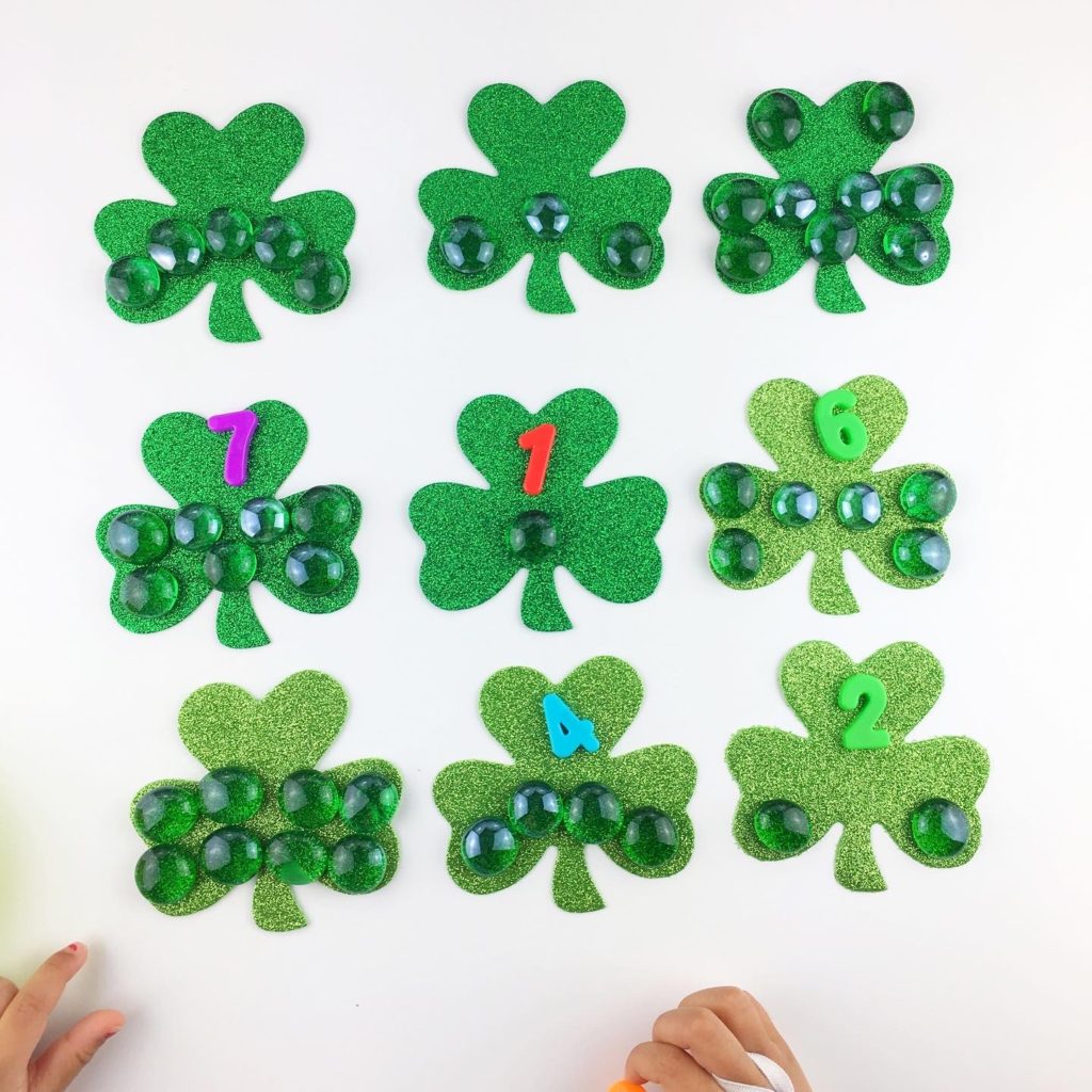 nine shamrocks with glass gems and corresponding numbers on top, but not in numerical order