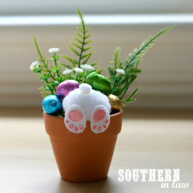 small pot with bunny feet, candy, and faux flowers