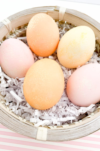 5 Kool-Aid-dyed Easter eggs in a basket filled with shredded paper