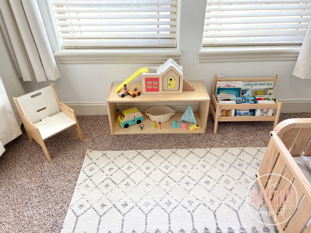 montessori infant shelf furniture sitting on the floor with toys on top.