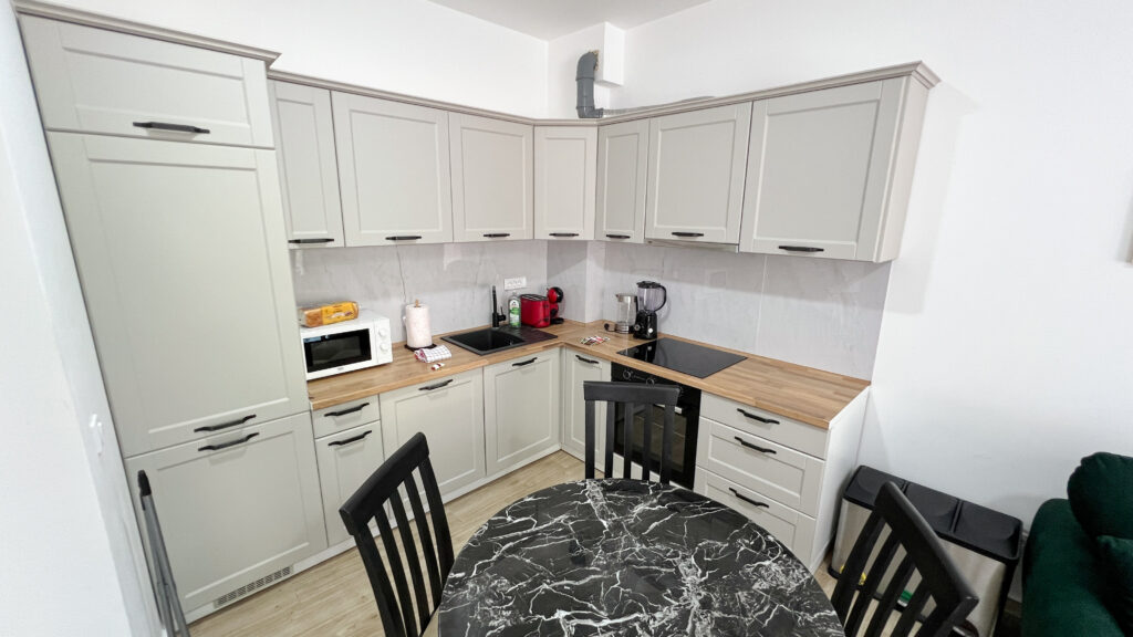 Scurda apartment gray kitchen cabinets with dining table in front
